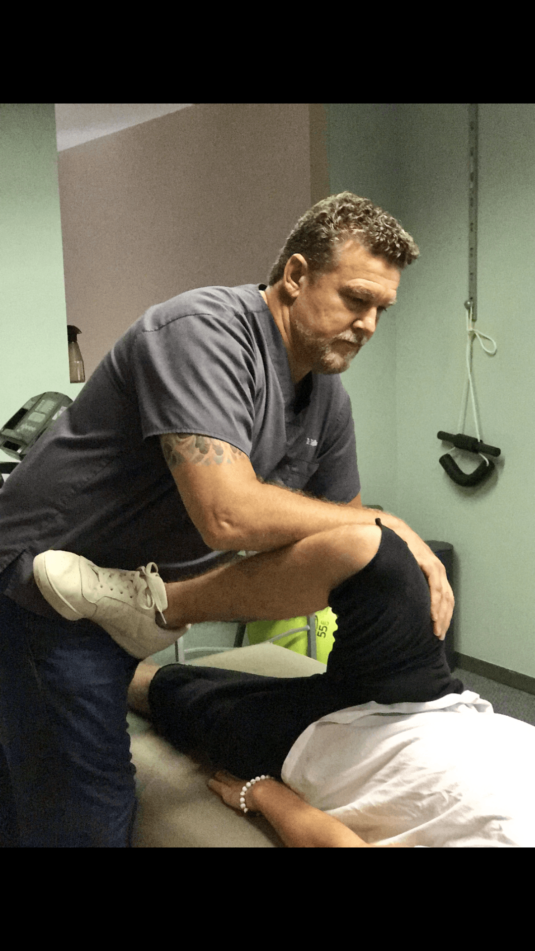 Dr. Eric Miller guiding a patient through a glute stretch