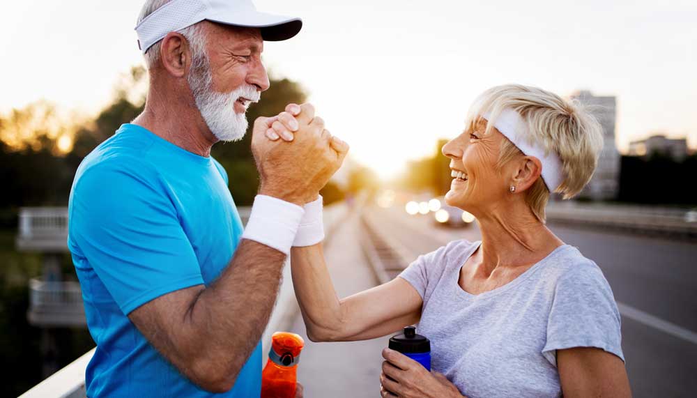 Energetic older couple celebrating an active, healthy lifestyle outdoors